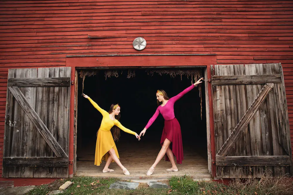 Women dancing by barn